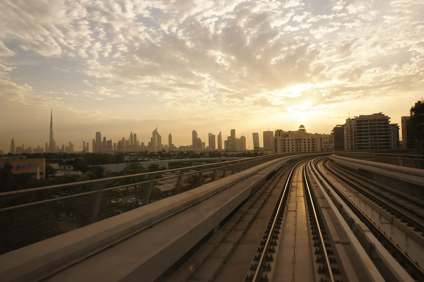 Dubai Metro tracks running toward the sunset skyline